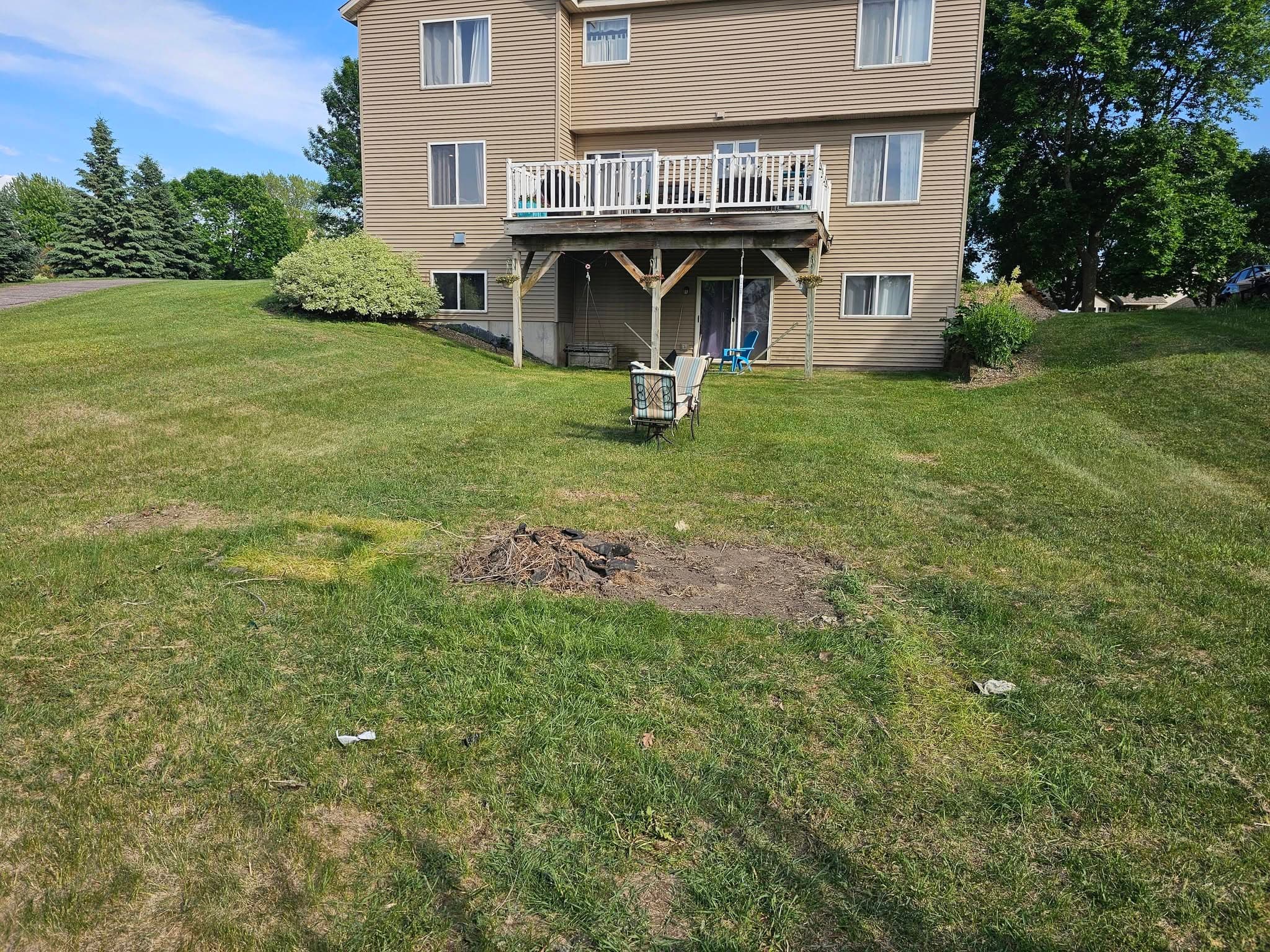 Residential back lawn after most of a large outdoor debris pile was removed.